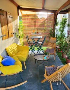 MatouryLa Villa Louisia的庭院配有黄色家具和桌椅