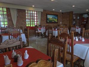 阿基塔尼亚Hotel Refugio Santa Ines的用餐室配有桌椅和白色的桌布