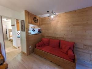 夏蒙尼-勃朗峰Appartement Chamonix-Mont-Blanc, 2 pièces, 4 personnes - FR-1-343-250的配有木墙的客房内的红色沙发