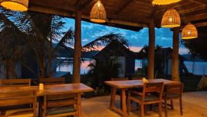 万荣Sunset Nam Ngum resort的一个带桌椅的海景庭院
