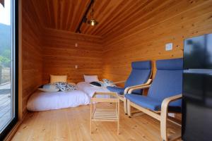 南阿尔卑斯市おそとのてらす　南アルプス的一间设有两张床和两把椅子的房间