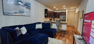 休斯顿Stylish Downtown Retreat的一间带蓝色沙发的客厅和一间厨房