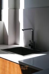 龙目岛库塔VILLA TERAUM的厨房水槽和黑色台面