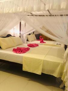 乌纳瓦图纳Coral Palm Villa and Apartment的一间卧室配有两张红色玫瑰床。