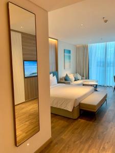 下龙湾Panoramic sea homestay的一间卧室配有一张大床和镜子