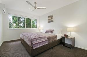 努萨维尔Ivory Palms Resort Noosa的一间卧室设有一张床和一个窗口