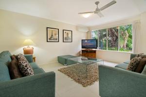 努萨维尔Ivory Palms Resort Noosa的客厅配有2张蓝色沙发和1台电视