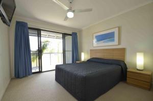 努萨维尔Ivory Palms Resort Noosa的一间卧室设有一张床和一个大窗户