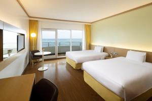 Susupe塞班岛世界度假酒店的酒店客房设有两张床和窗户。