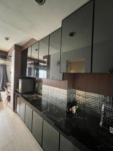 SunggalSkyview Setiabudi Apartment的厨房配有黑色台面和镜子