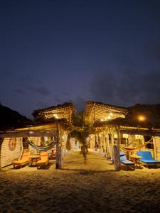 圣维森特Hotel Gabarra Lodge的海滩上的度假村,晚上配有桌椅