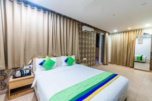 浦那Treebo Trend Spring Brooks - Kalyani Nagar的卧室配有白色大床和窗帘
