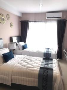 SunggalSkyview Setiabudi Apartment的一间卧室设有两张床和大窗户