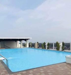 SunggalSkyview Setiabudi Apartment的一座大型蓝色游泳池,位于一座建筑的顶部