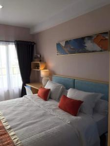 SunggalSkyview Setiabudi Apartment的一间卧室配有一张大床和两个红色枕头