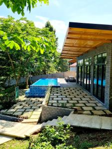 河内Villa Ba Vi 6 Bedrooms & Pool DC Green Resort的一个带游泳池和房子的后院