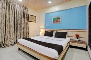 孟买Collection O Guru Heritage Kalamboli的一间卧室设有一张蓝色墙壁的大床