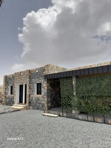 Sa‘ab Banī KhamīsCloud housing jabal shams的一座带绿色墙壁的石头建筑