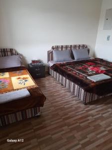 Sa‘ab Banī KhamīsCloud housing jabal shams的一间卧室设有两张床,铺有木地板