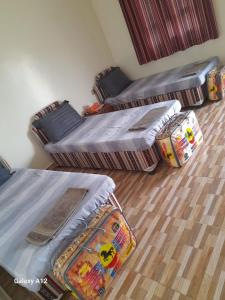 Sa‘ab Banī KhamīsCloud housing jabal shams的客房内的3张床和1张沙发