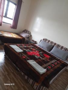 Sa‘ab Banī KhamīsCloud housing jabal shams的一间卧室设有两张床和窗户。