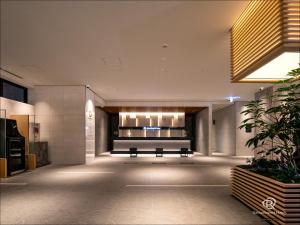 福山Daiwa Roynet Hotel Fukuyama Ekimae的大楼里一个空的大厅,有长凳