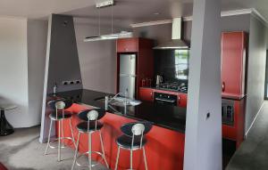 马丁伯勒马丁博勒德藤26号度假屋的厨房配有红色橱柜和带凳子的台面