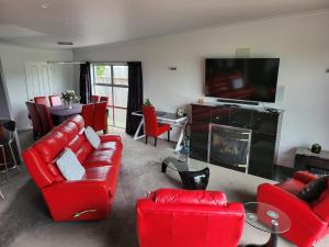 马丁伯勒马丁博勒德藤26号度假屋的客厅配有红色家具和平面电视