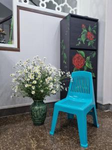 河内May's Cottage的花瓶旁边的蓝色椅子