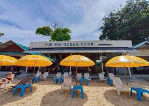 皮皮岛Phi Phi Ocean Club的海滩上的一组椅子和遮阳伞