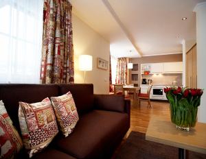平茨高谷地霍勒尔斯巴赫Sonnblick Apartments und Zimmer - Nationalpark Sommercard inklusive的客厅配有沙发和红色玫瑰桌