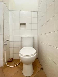 BlimbingSPOT ON 93398 Sudimoro Guest House Syariah的浴室内设有一个白色的卫生间,配有软管