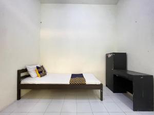 BlimbingSPOT ON 93398 Sudimoro Guest House Syariah的小房间设有一张床和一张书桌