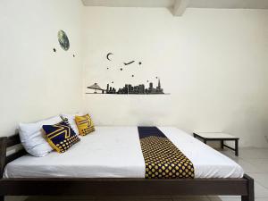 BlimbingSPOT ON 93398 Sudimoro Guest House Syariah的一间卧室配有黄色和蓝色枕头的床
