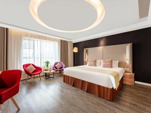 西安康铂酒店（西安大雁塔大唐不夜城店）的酒店客房,配有一张床和一张红色椅子