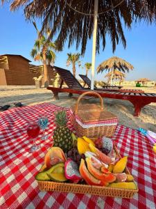 Cielo Beach Resort的野餐桌,包括一篮水果和一杯葡萄酒