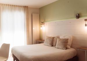 沙特拉永普拉日Hôtel Le Rivage vue sur mer - Châtelaillon-plage的卧室配有一张大白色床和窗户