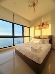 哥打京那巴鲁Sunset Seaview Studio Apartment at Kota Kinabalu City Centre的一间卧室设有一张床,享有海景