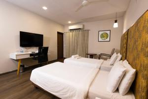 维沙卡帕特南Classic Boutique Hotel & Luxury Service Apartments的酒店客房配有两张床和一张书桌
