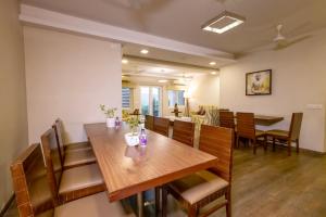 维沙卡帕特南Classic Boutique Hotel & Luxury Service Apartments的一间带木桌和椅子的用餐室