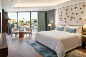 切什梅Reges, a Luxury Collection Resort & Spa, Cesme的卧室配有一张白色大床,墙上有鸟儿