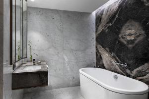 切什梅Reges, a Luxury Collection Resort & Spa, Cesme的浴室配有白色浴缸和水槽