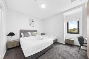 悉尼Urban Oasis in Heart of Homebush的白色的卧室设有一张大床和一个窗户