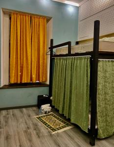 巴统Communication hostel的一间卧室配有带绿色和黄色窗帘的双层床