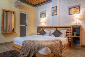 卡绍利Kasauli dream hills的卧室配有一张带白色床单和枕头的大床。