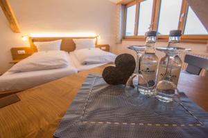雷滕贝格Gasthof Hirsch Vorderburg的一间卧室配有两张床和两瓶葡萄酒