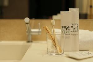 赫罗纳赫罗纳城市酒店的浴室水槽上的牙刷和牙膏管