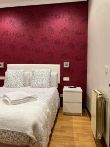 马德里Hostal New Dream Madrid的一间卧室设有一张床和红色的墙壁