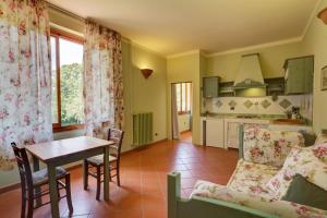 基安蒂格雷夫Albergo Villa San Michele的厨房以及带桌子和沙发的客厅。
