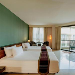 七岩七岩海滩塔拉曼特拉度假酒店的酒店客房设有两张床和一张桌子。